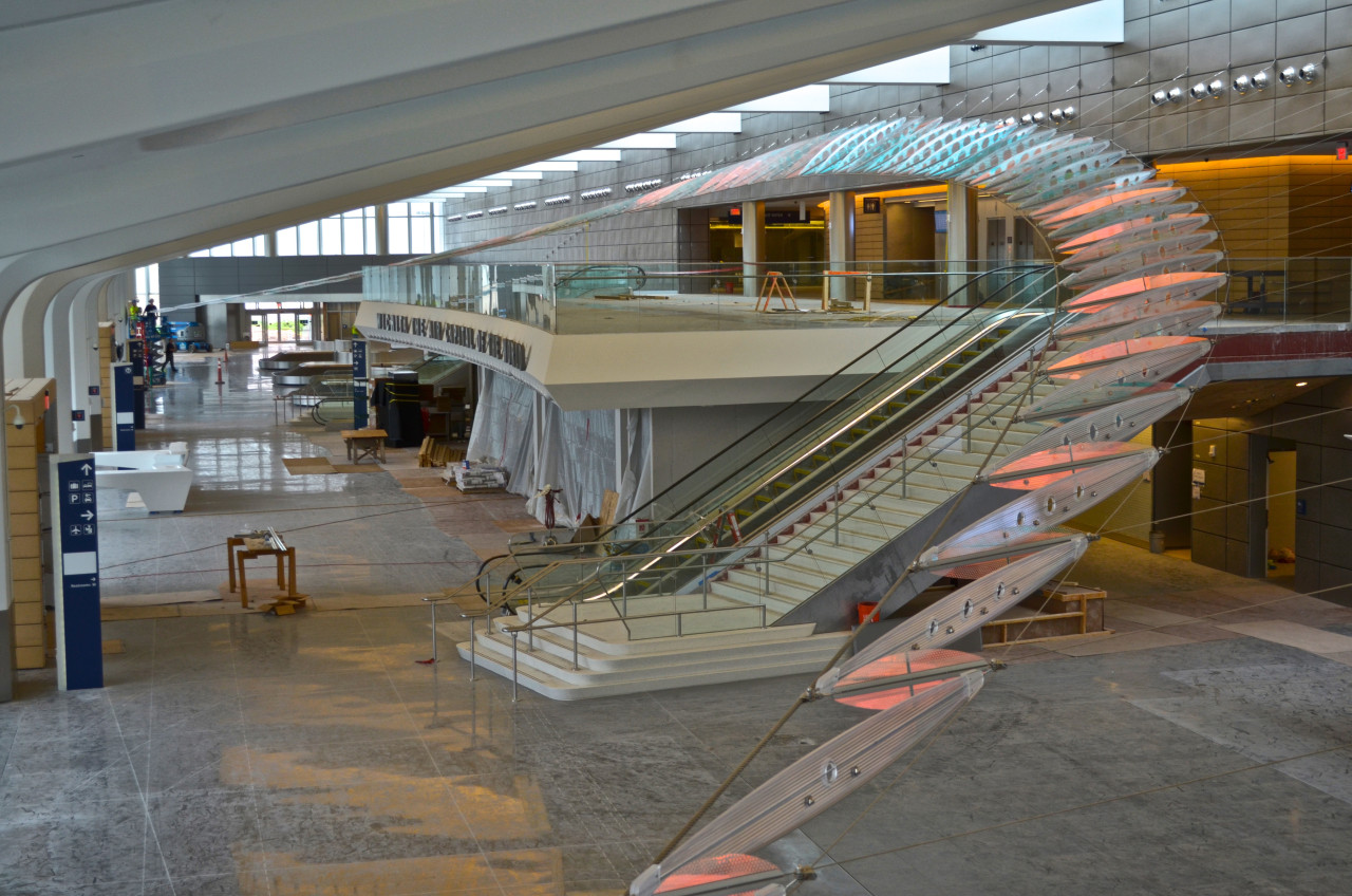 Ed Carpenter’s Dwight D. Eisenhower National Airport sculpture Aloft in Wichita, Kansas, soars from one end of the building to the other like an enormous abstract wing. Here is an overall view of the lobby sculpture made of laminated dichroic safety glass, stainless steel cables and hardware, and cellular polycarbonate. | Image 1 | Ed Carpenter, Artist