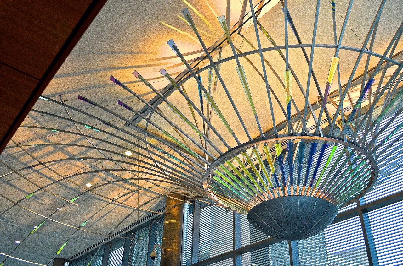 Ed Carpenter’s Radius suspended dichroic glass art lobby sculpture emanates outward through the Ann Arbor Justice Center lobby with dichroic glass and concealed lighting. | Image 1 | Ed Carpenter, Artist