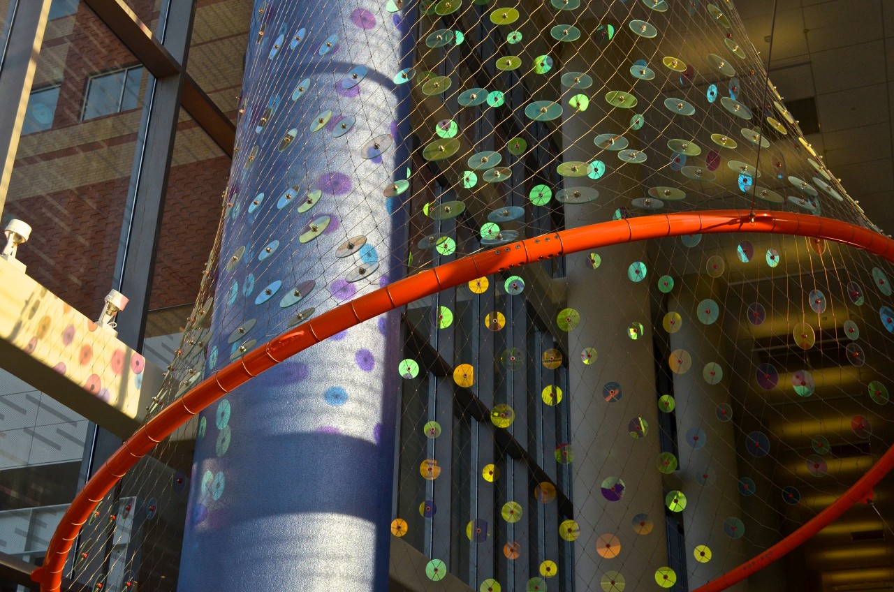 Ed Carpenter’s Foxglove suspended glass art sculpture for San Antonio’s new university’s hospital lobby close up image of the stainless steel net and painted ring with jewels of dichroic glass. | Image 3 | Ed Carpenter, Artist