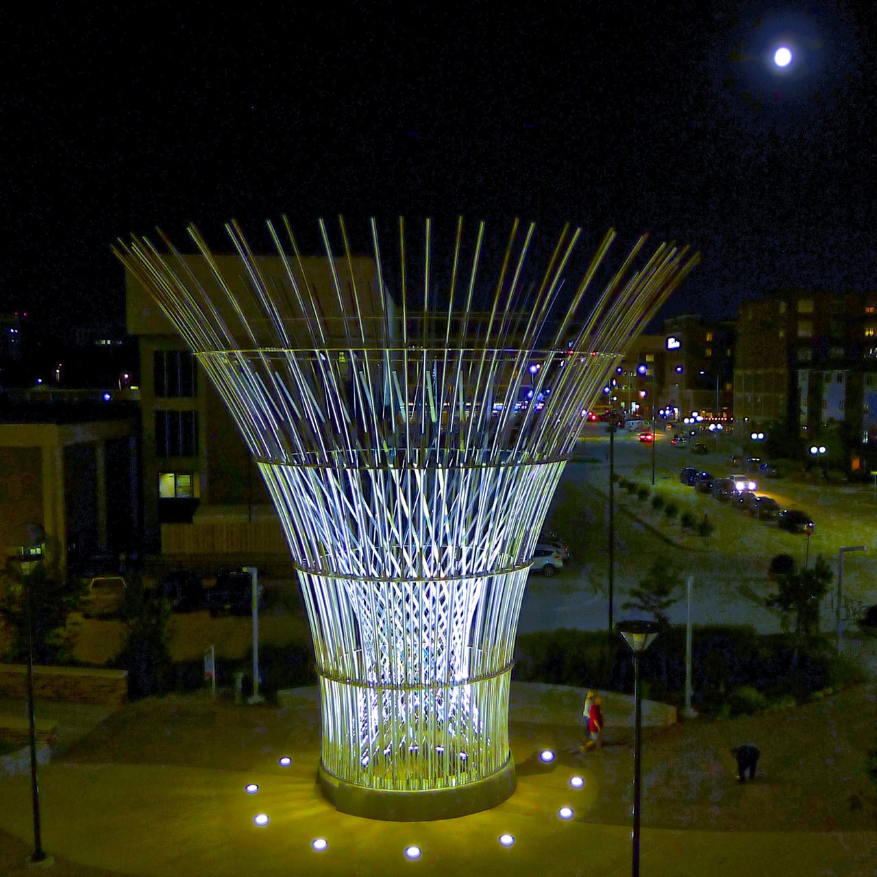 Harvest monumental public sculpture in Lincoln, Nebraska night lighting in the plaza in front of the Pinnacle Bank Arena amplifies the laminated dichroic glass elements crisscrossing in the center of the sculpture. | Image 3 | Ed Carpenter, Artist